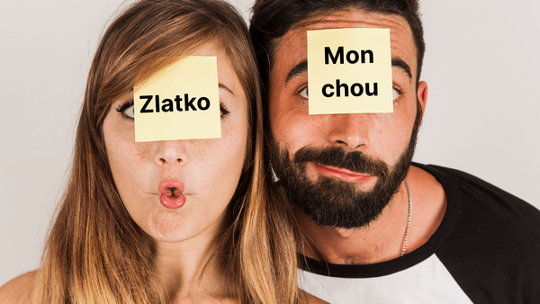 A couple with sticky notes on their faces, displaying romantic nicknames in French and Croatian.